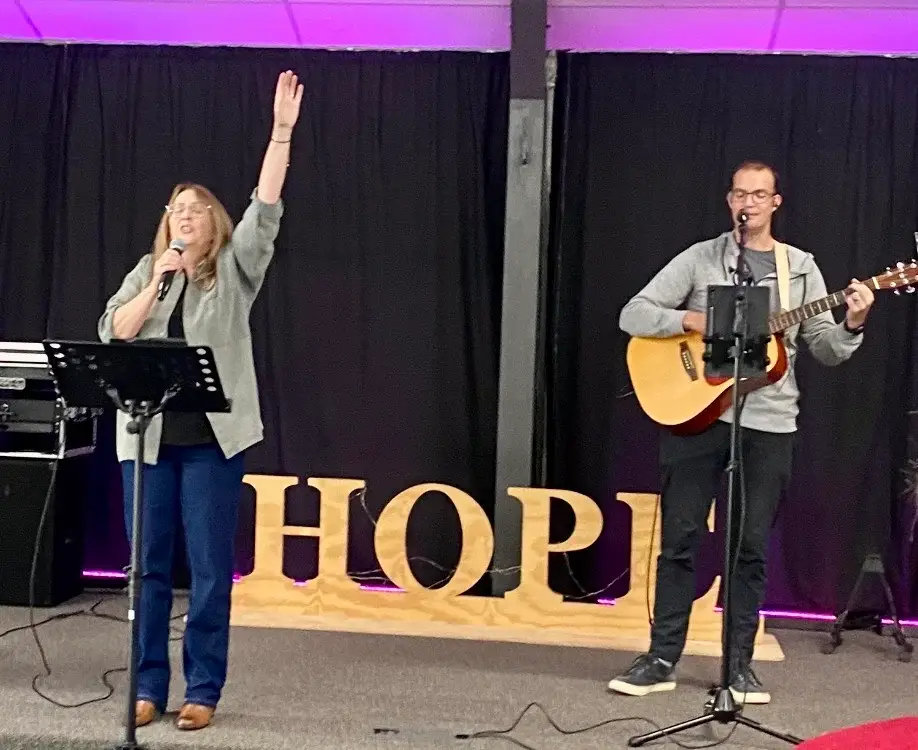 Congregation with hands raised in worship